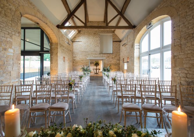 Interior of our Cotswold wedding venue, looking west down the aisle in Stone Barn