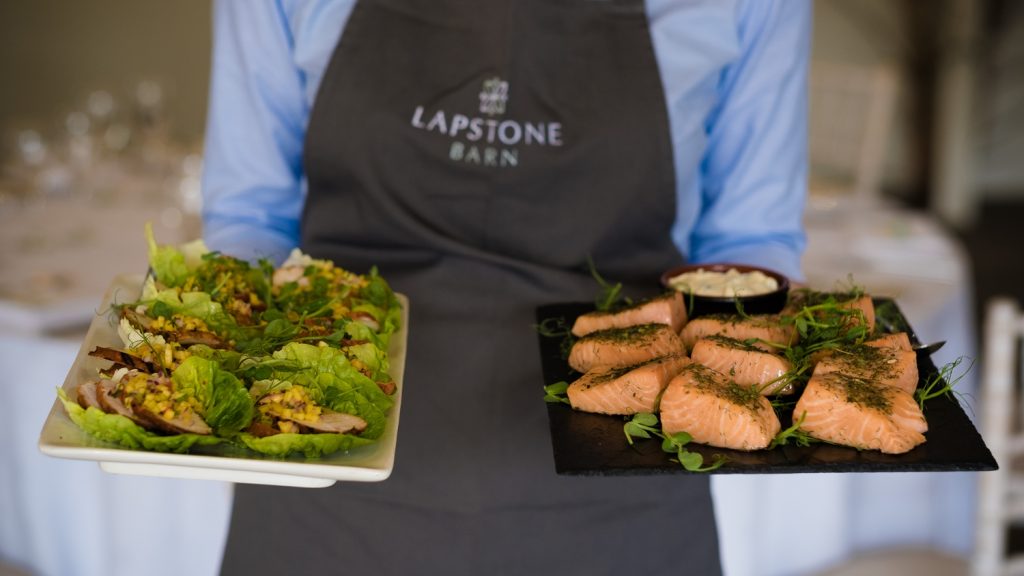 Waitress with Lapstone Barn apron on carrying salad platters