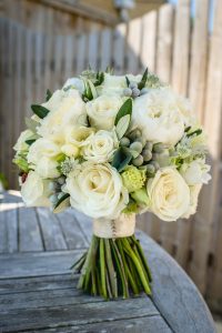 Hand tied bridal bouquet in whites and soft neutrals, perfect for a barn wedding venue