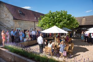 Guests enjoying drinks and canapes at the wedding reception in the courtyard. Photography: Rachel Jones Photography