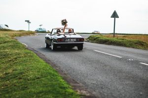 Bride and groom leaving their wedding in the Cotswolds by car