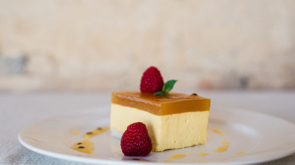 Mango & Passion Fruit Cheesecake served on a white plate