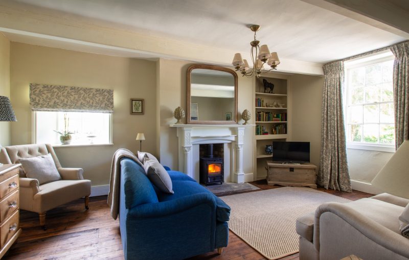 The comfortable sitting room with sofas, armchairs and beautiful fireplace