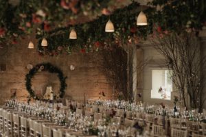 Floral bars hanging over the rows of tables laid for the wedding breakfast