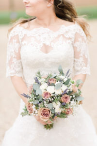 Bride holding her bridal bouquet of soft pastel colour flowers