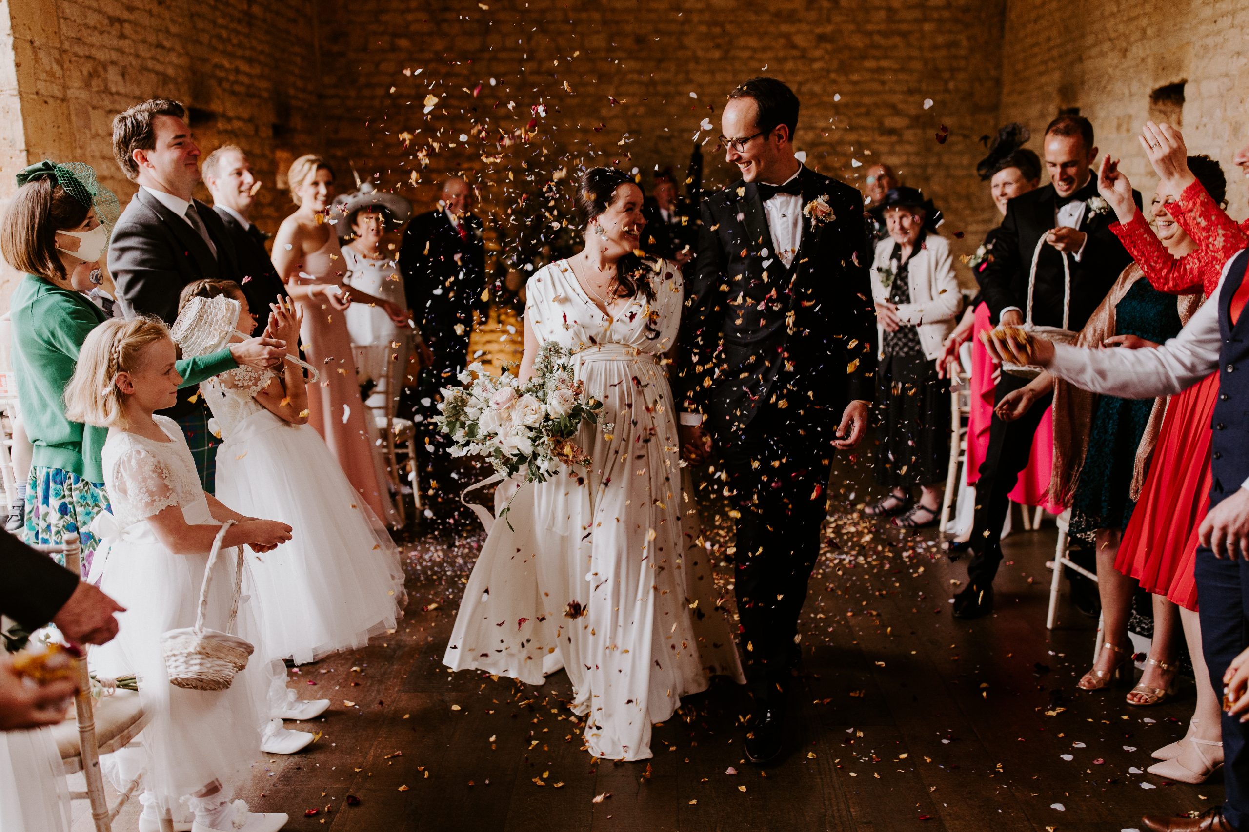 Bride and groom walking through confetti
