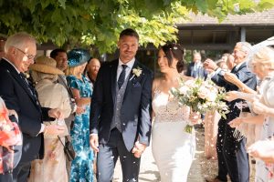 Bride and groom hand in hand after outdoor wedding ceremony