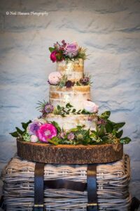 Semi naked wedding cake decorated with fresh flowers