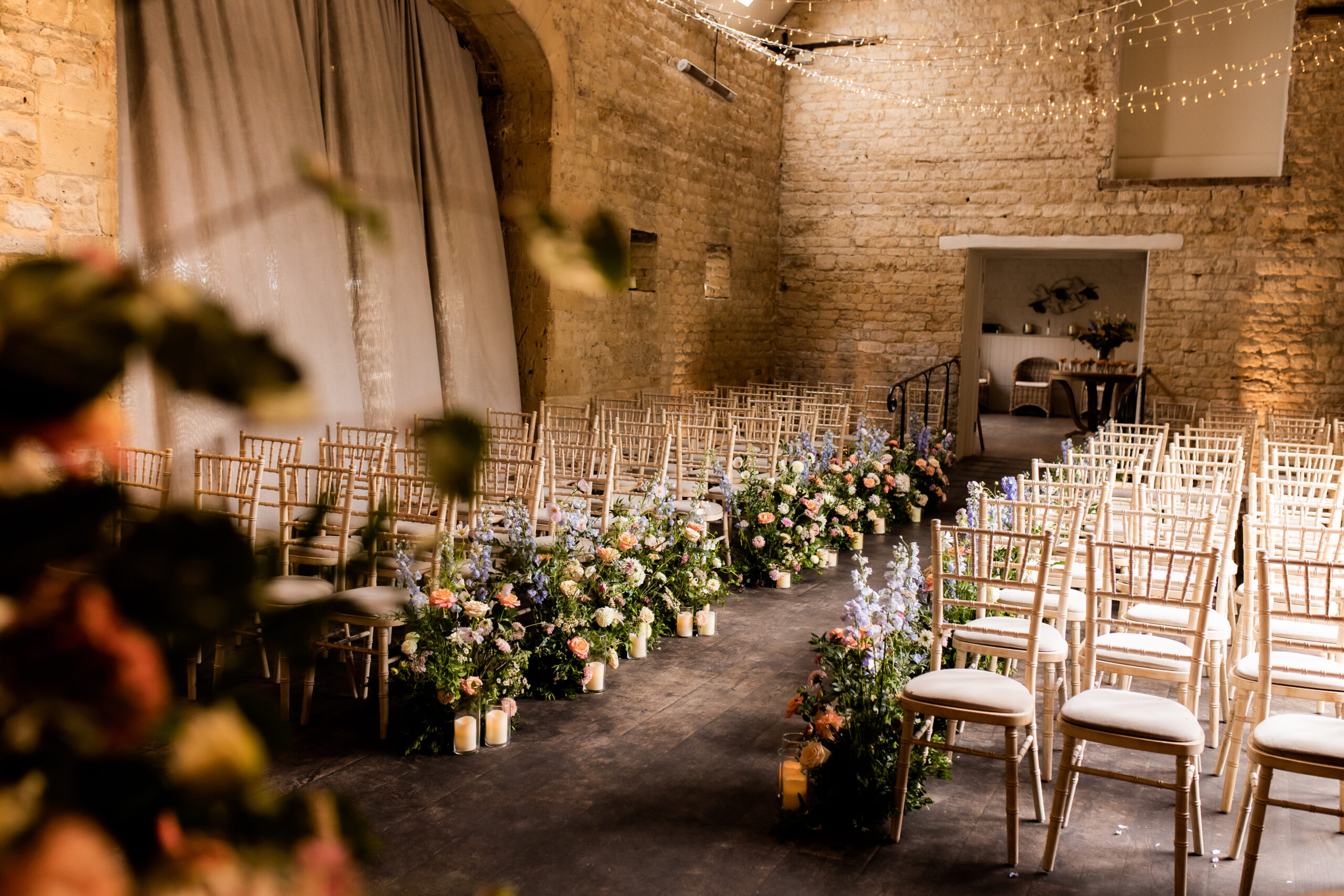 Meadow flowers dress the aisle at Lapstone Barn before the wedding ceremony